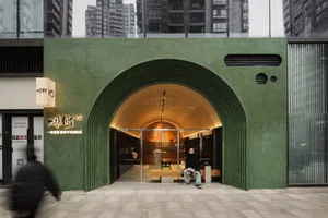 A bustling Asian restaurant with green walls, an archway entrance, and patrons enjoying meals on benches and chairs