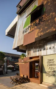 Rustic cafe interior with a blend of traditional and modern elements, featuring wood and metal accents, potted plants, and dining tables and chairs
