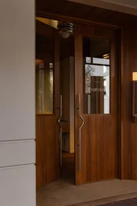 A dimly lit hallway with a wooden door and window, creating a warm and cozy atmosphere