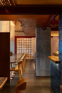 A clean and welcoming restaurant interior with a long dining table surrounded by chairs, ready for guests to arrive and be seated