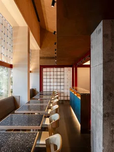 A modern restaurant interior with multiple dining tables and chairs, creating a welcoming atmosphere with ample seating options