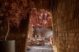 Elegant dining space with multiple tables, chairs, and various decorative items, featuring wood elements in the design