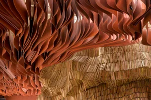 A wooden structure in a cozy space with variously sized books stacked in different orientations, creating a unique display