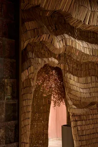 A bookshelf made of stacked books forms a doorway, inviting exploration of a world behind, with various book sizes and orientations adding depth and complexity