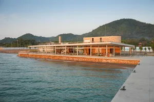 Modern waterfront building with glass walls, multiple levels, and natural light