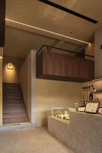 Open living area with wooden floors and walls, featuring a combined kitchen, dining, and living space with comfortable seating and a dining table
