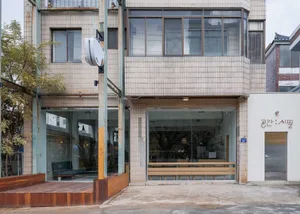 A restaurant interior with multiple dining tables and chairs, surrounded by a brick building with large windows