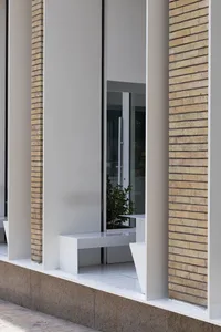 A brick building facade with three benches in front, creating a calm and inviting atmosphere