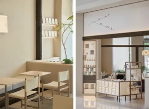 A restaurant or commercial dining space with chairs around a table, a bench near a wall, and potted plants, featuring wood and metal materials in a modern and stylish setting