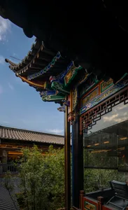 Ornate Asian building with a large wooden structure featuring intricate carvings and decorations, adorned with vibrant colors and patterns