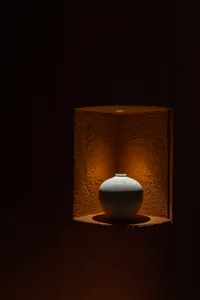 A cozy home interior with a ceramic vase on a brown surface, suggesting a warm and inviting atmosphere