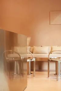 A modern living space with beige walls, a couch, chairs, and a dining table, creating a cozy atmosphere
