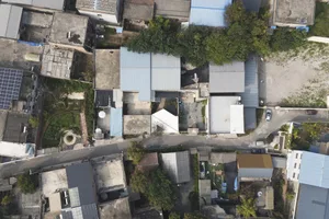 Aerial view of a city neighborhood with various buildings, trees, and greenery
