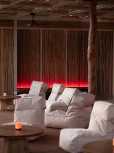 Cozy dining space with a large wooden beam, chairs, and a dining table, creating a warm atmosphere