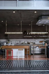 Modern kitchen with wood floors, white cabinets, marble countertops, and various appliances, giving a luxurious and lived-in feel