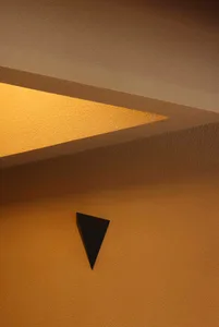 A rendered interior scene featuring a prominent triangle shape on a yellow background, with a focus on functionality and aesthetics