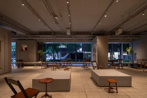 A modern living-dining space with multiple chairs, a large window, and a bright atmosphere, suitable for gatherings or social events