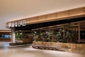 A cozy indoor space with potted plants, dining tables, and chairs, creating a welcoming atmosphere for customers