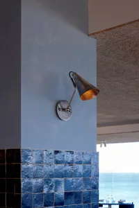 A modern interior space with a metal lamp on a tile wall, giving a clean and well-lit atmosphere