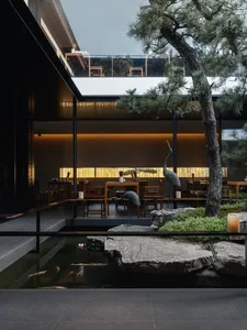 Dining room with modern design, concrete walls, and natural light from a large window