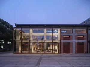 A large building with many windows on its facade, surrounded by chairs for outdoor gatherings, conveying a sense of grandeur and functionality