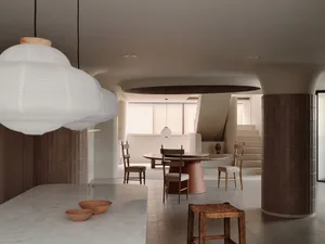 Cozy modern living space with a large dining table, chairs, kitchen sink, and countertops