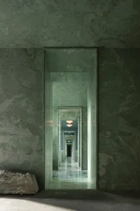 A large marble hallway with multiple mirrors reflecting the surroundings, creating a warm and sophisticated atmosphere