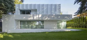 A sleek modern building with a white facade, multiple windows, and clean lines, suggesting a sense of elegance and sophistication