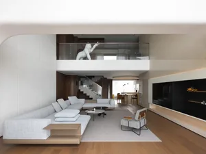 Open modern living area with a couch, chairs, dining tables, TV, and decorative vase