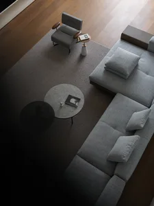 Open living area with a large couch, two chairs, a dining table, and a laptop, creating a comfortable and inviting atmosphere