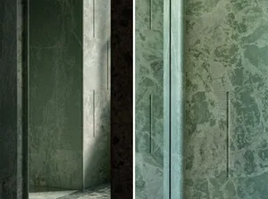 Bathroom with green marble walls, a sink area, and a mirror, featuring a doorway and a contrasting darker wall in a second view