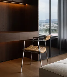 Comfortable living area with a couch, chair, and dining table, featuring wooden floors and walls, and a view of the outside through a window