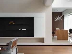 Modern open concept living space with a black entertainment center, flat screen TV, two chairs, and minimalistic decoration