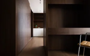 Dark wood panelled hallway with a wooden floor, a door, and two potted plants adding greenery to the space