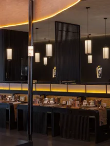 A restaurant dining area with wooden tables, chairs, and multiple cups, creating an inviting and comfortable atmosphere for guests