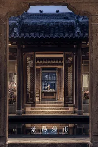 Asian-style building with a wooden structure, tile roof, and a large window allowing natural light to enter the interior