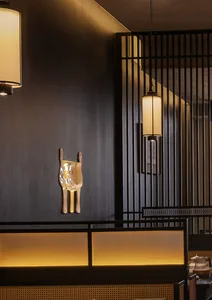 A warm and inviting restaurant dining area with a wooden table, chairs, chandeliers, and artwork on the walls