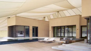 Open living area with wooden deck, pool, and comfortable seating arrangement, surrounded by a relaxing atmosphere