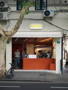 A modern cafe with a warm atmosphere, featuring wood and metal elements, natural light, and a spacious layout with seating and dining areas