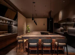 Warm and inviting kitchen with wooden floors, marble countertops, and a large island surrounded by chairs