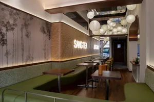 Cozy Asian restaurant interior with wooden floors, bamboo walls, and dim lighting
