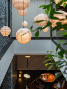 Spacious dining area with a concrete wall, a dining table, and hanging lights