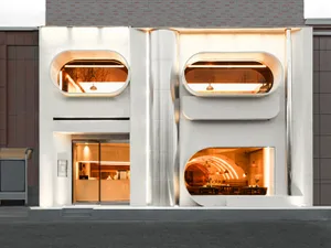 A modern building with a large lit window, white and grey elements, and outdoor seating areas, conveying elegance and sophistication