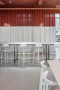 A restaurant interior with a long wooden table surrounded by multiple chairs, creating a warm and inviting atmosphere for guests