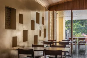 A restaurant interior with multiple dining tables and chairs, creating an inviting atmosphere for social gatherings