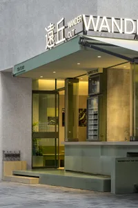 Spacious Asian restaurant entrance with glass doors, green and white walls, and comfortable seating areas