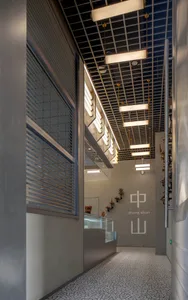 A large, well-lit gallery with concrete walls, multiple windows, and a spacious atmosphere, featuring several rooms and a modern industrial feel