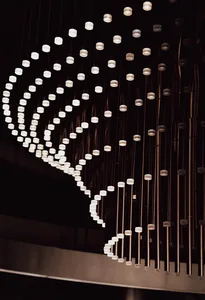 A modern interior space with a long row of suspended lights creating depth and dimension