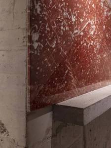 A modern staircase with a marble wall featuring a red tint, set against a clean and minimalistic background