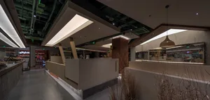 A warm and inviting indoor space with wooden floors and walls, featuring a living area and kitchen, with multiple people engaging in various activities